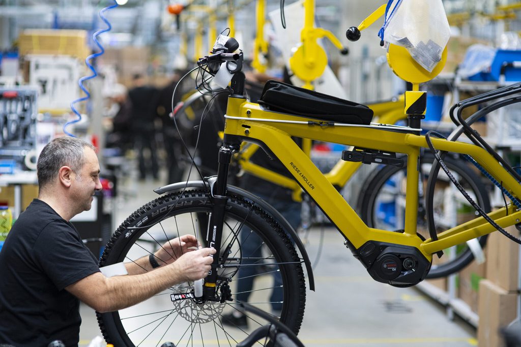 Monteur près d'une roue de vélo dans un support jaune suspendu