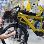 Monteur près d'une roue de vélo dans un support jaune suspendu